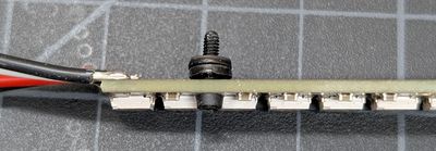 An image showing a bolt and two washers through one of the bolt holes on the NeoPixel Stick