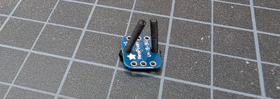 Breadboard-friendly NeoPixel face down with bolts coming out the top